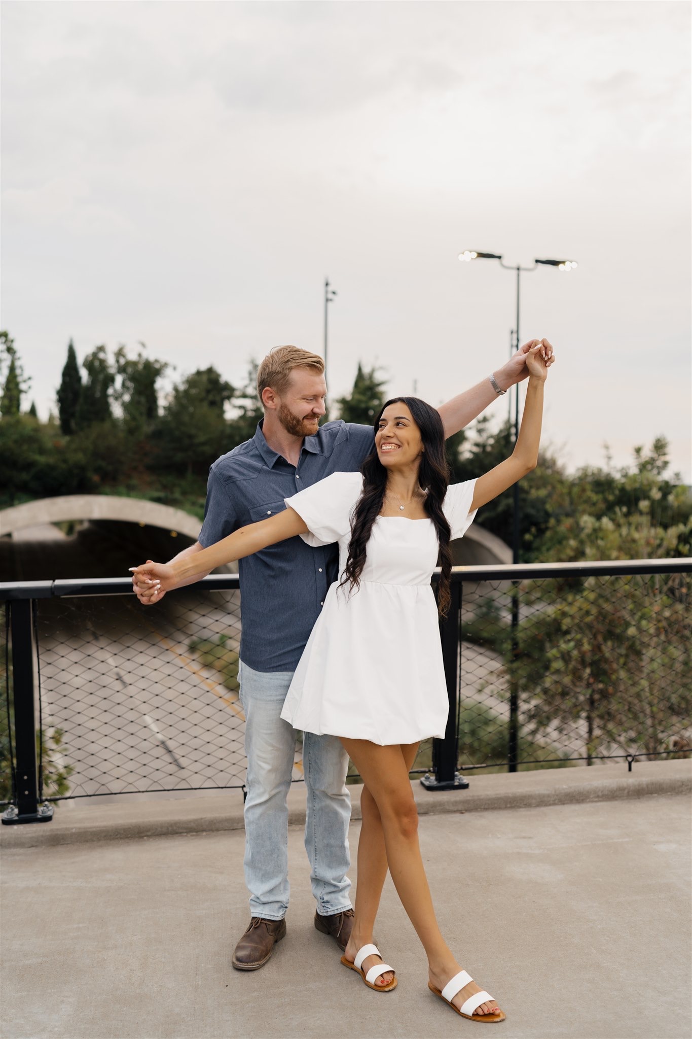 Couple holding hands during romantic Tulsa engagement photos at Gathering Place.