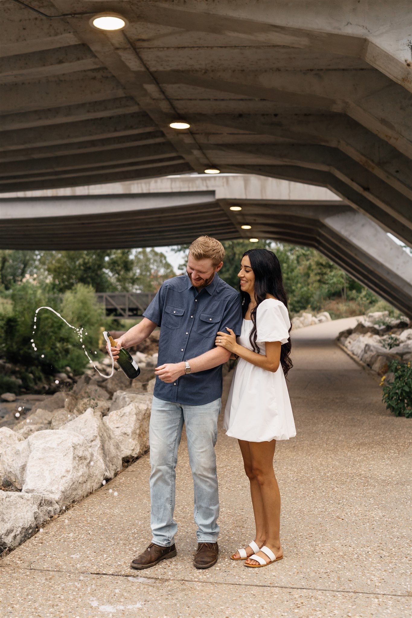 Romantic engagement photos with bridges and scenic Tulsa river at Gathering Place.