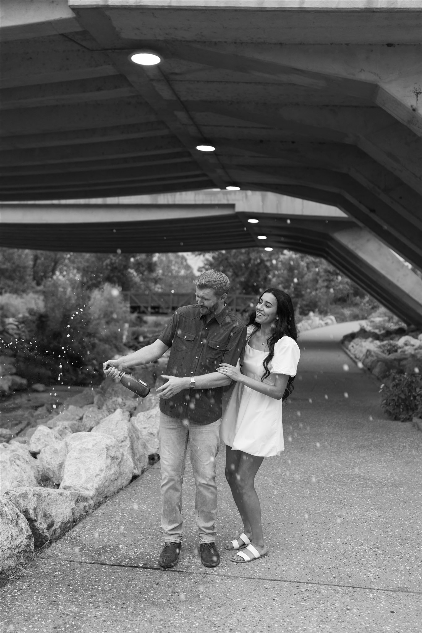 Couple celebrating engagement after a surprise proposal at Gathering Place in Tulsa.