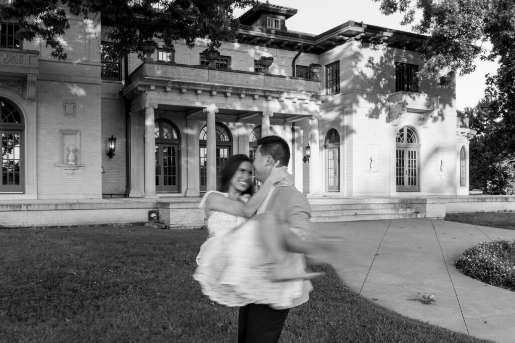 Bride-to-be twirling in front of the elegant white columns at The Mansion at Woodward Park