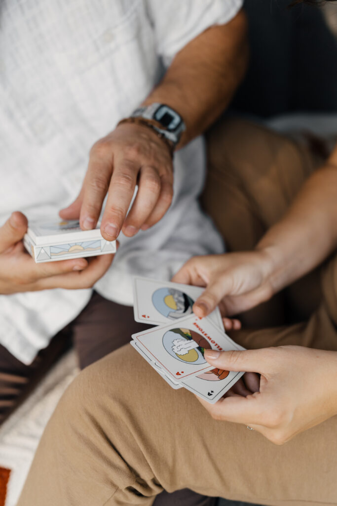 Engaged couple playing national park cards during their Oklahoma camping-inspired engagement session