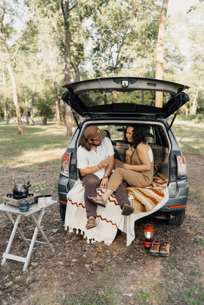 Engaged couple playing national park cards during their Oklahoma camping-inspired engagement session