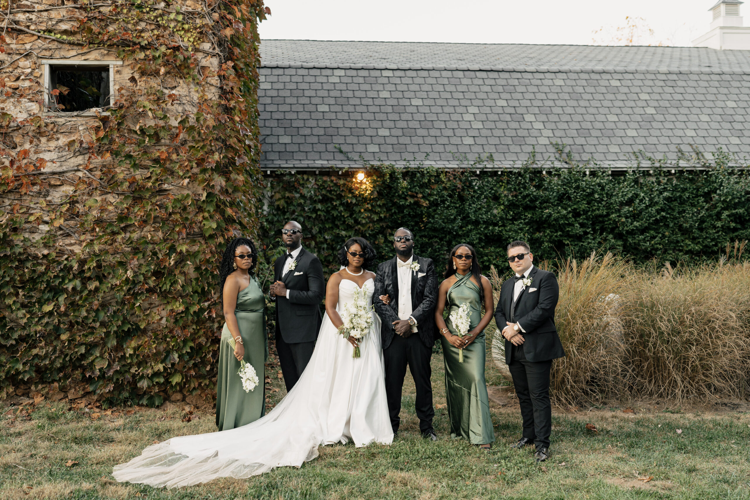 Bridal party in soft green dresses on mansion lawn