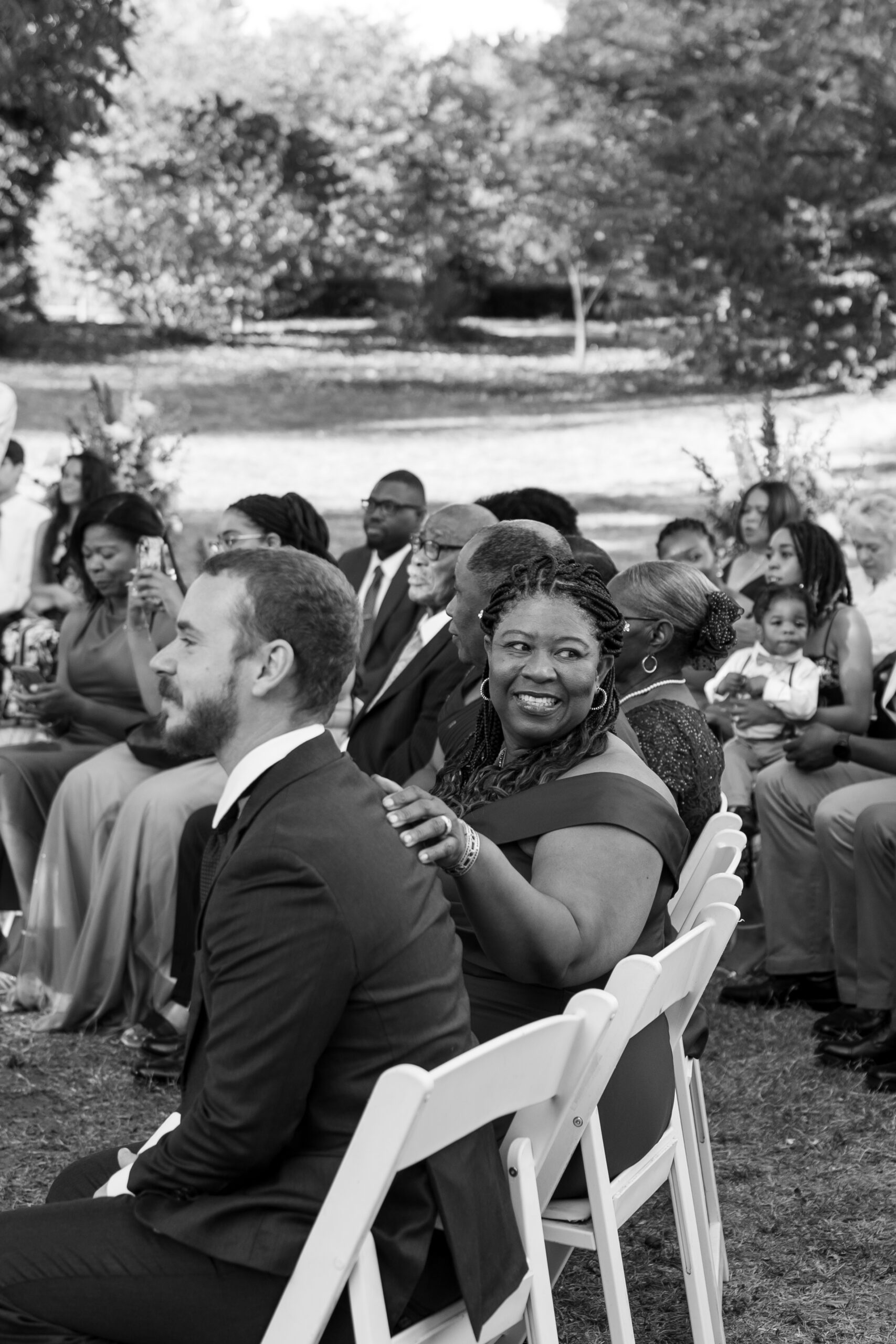 Wedding guests seated at rustic wooden benches for garden ceremony
