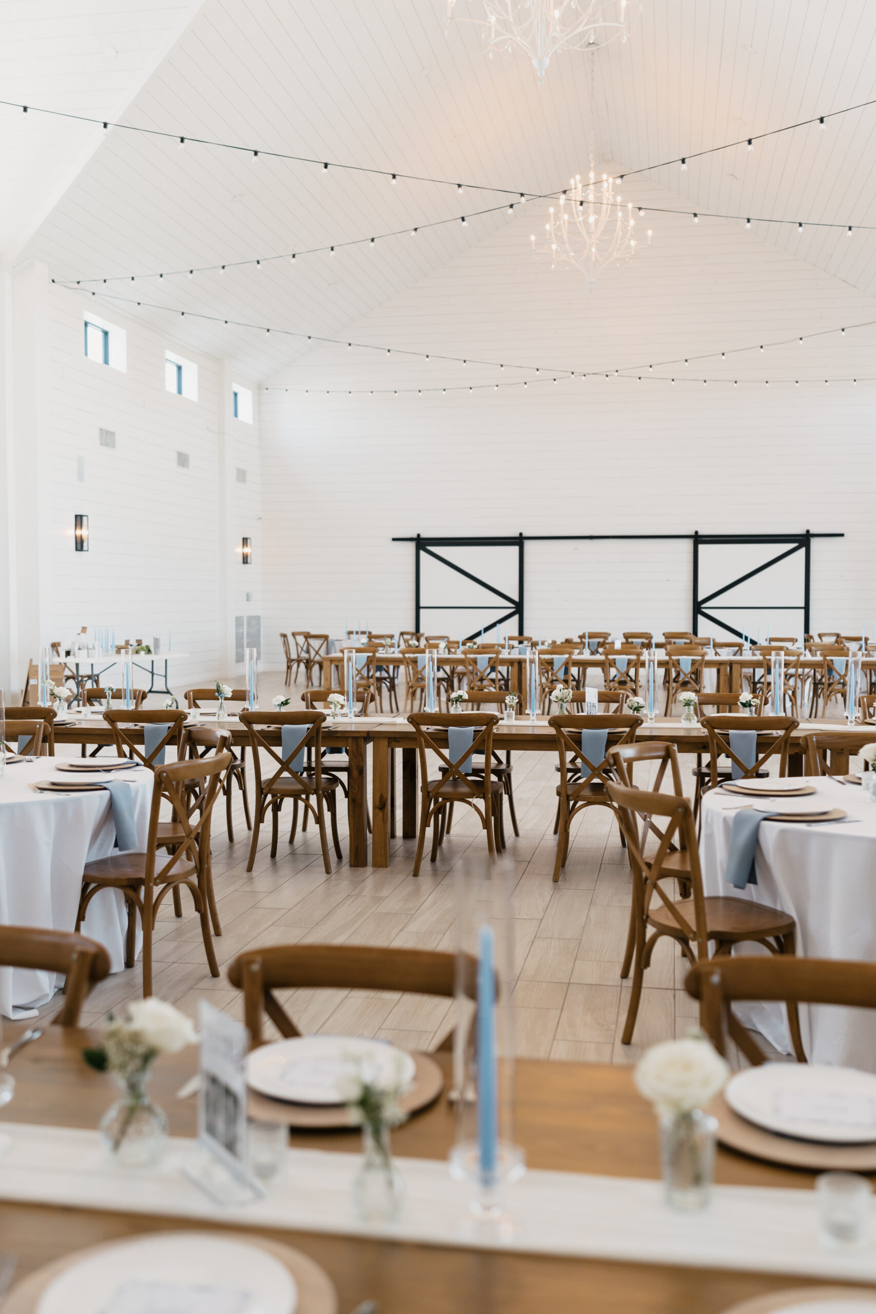 Table setup with floral centerpieces and candles inside The Gardenia wedding venue in Texas.
