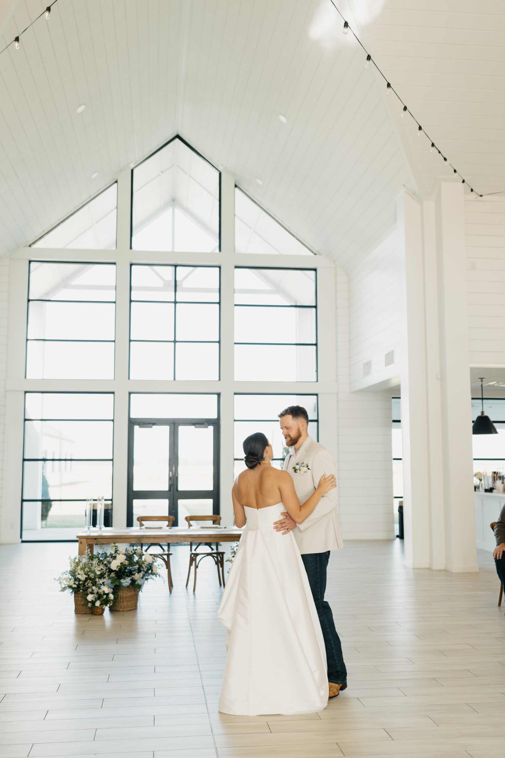 Reception hall at The Gardenia wedding venue featuring elegant chandeliers and neutral decor.