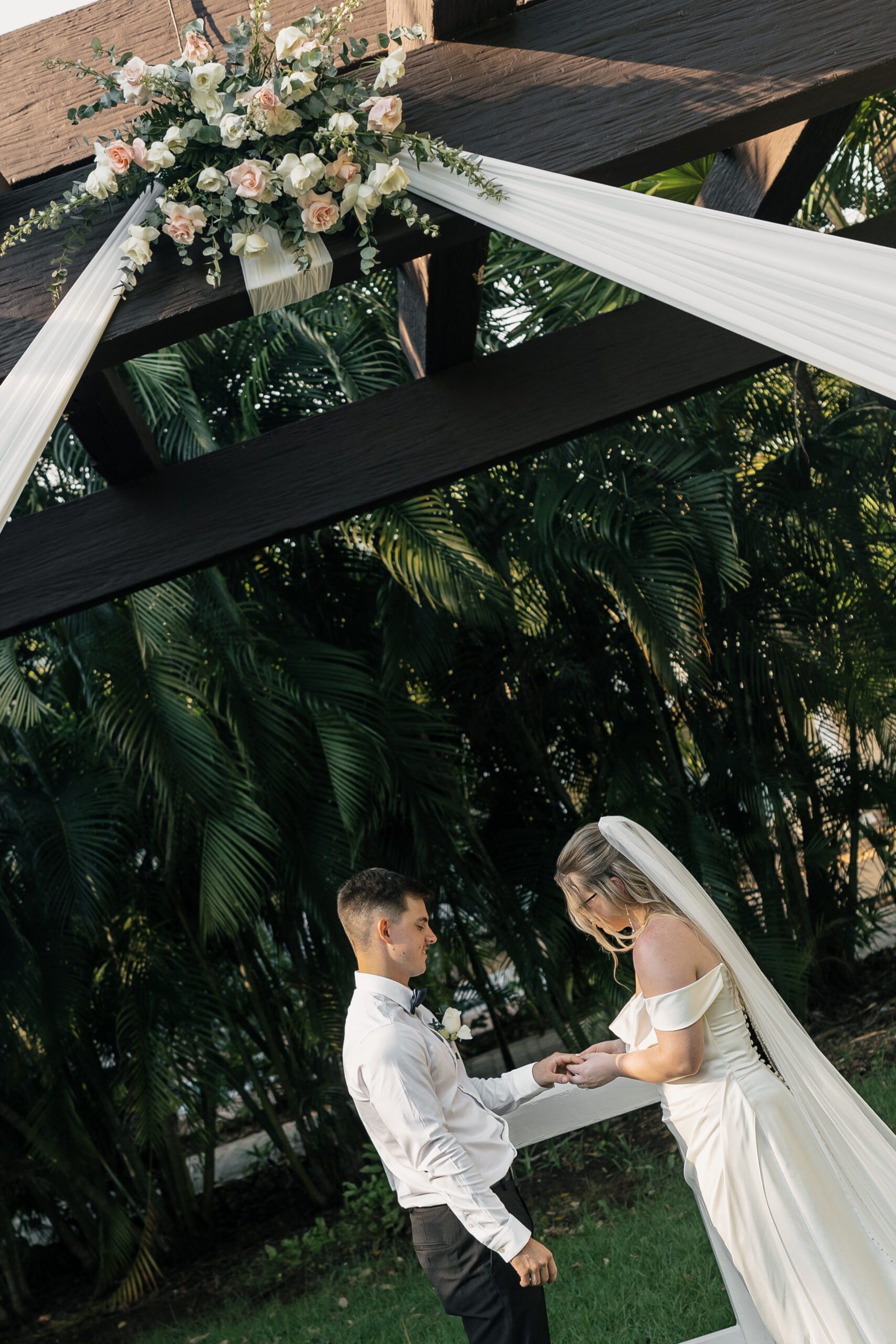 Couple exchanging vows under palm trees