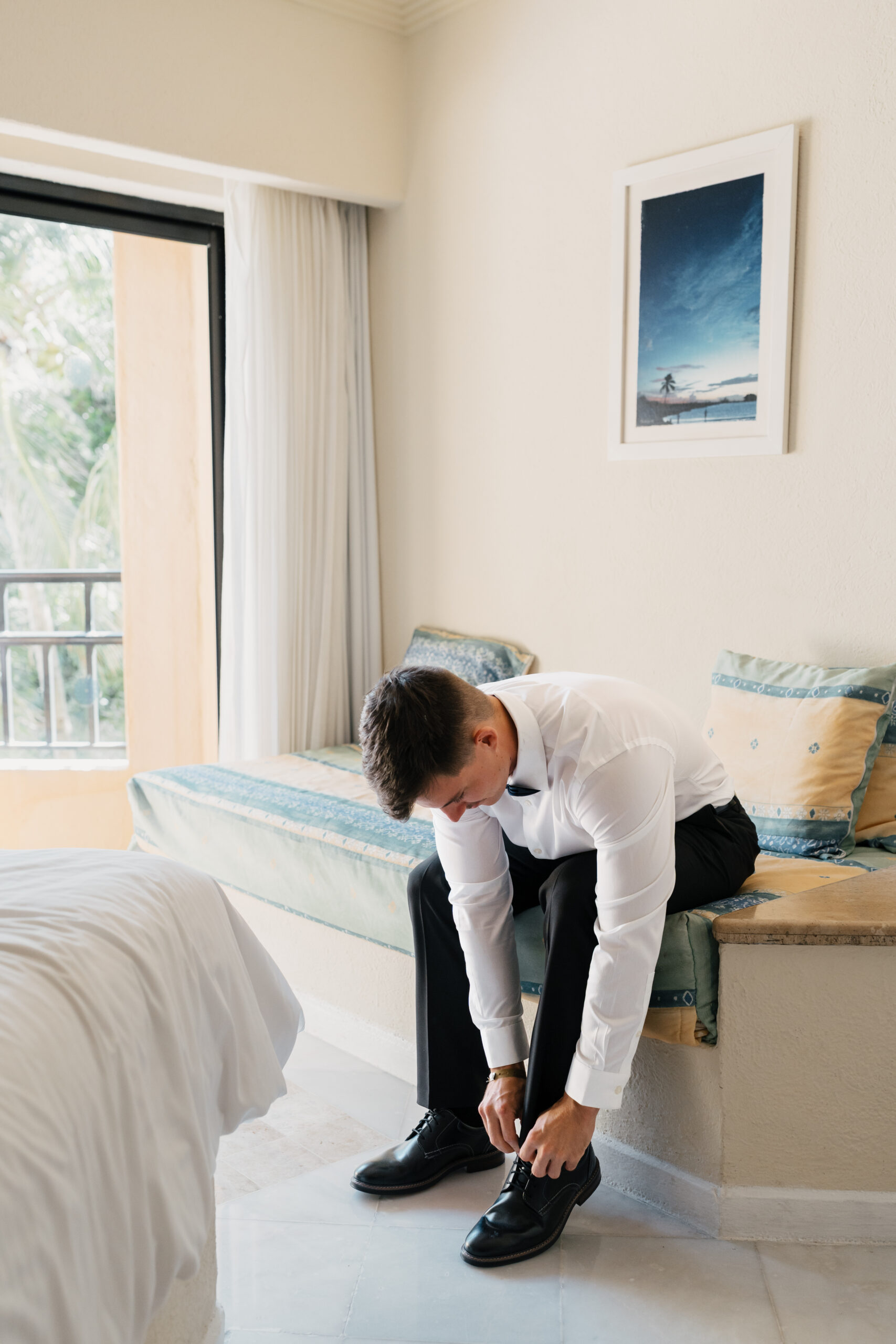Groom adjusting tie before wedding at Sandos Playacar