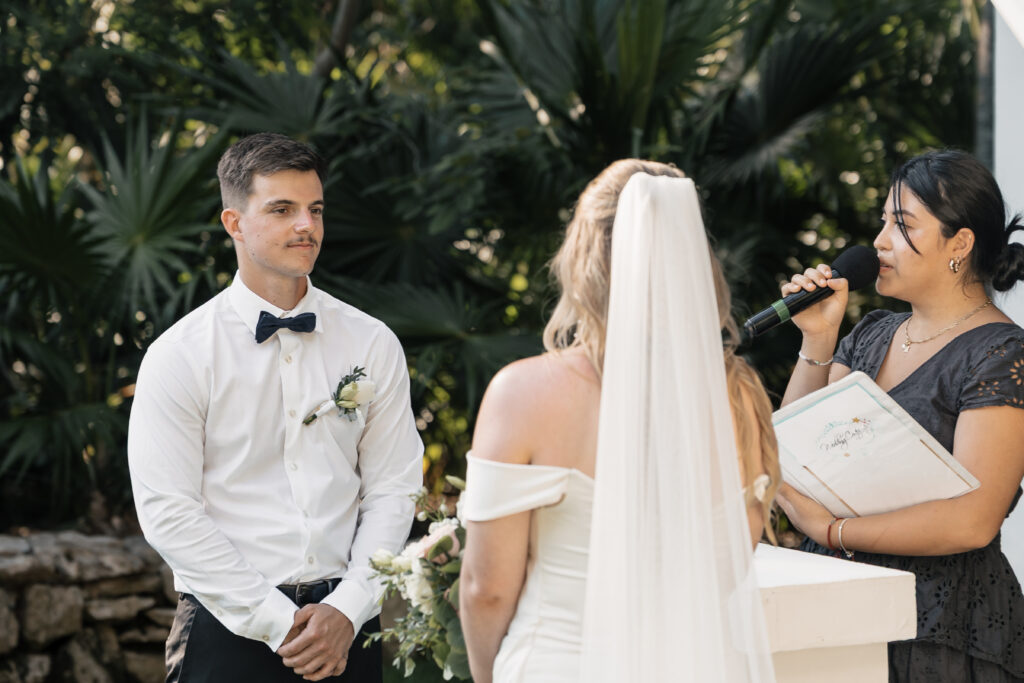 Groom watching bride during tropical ceremony