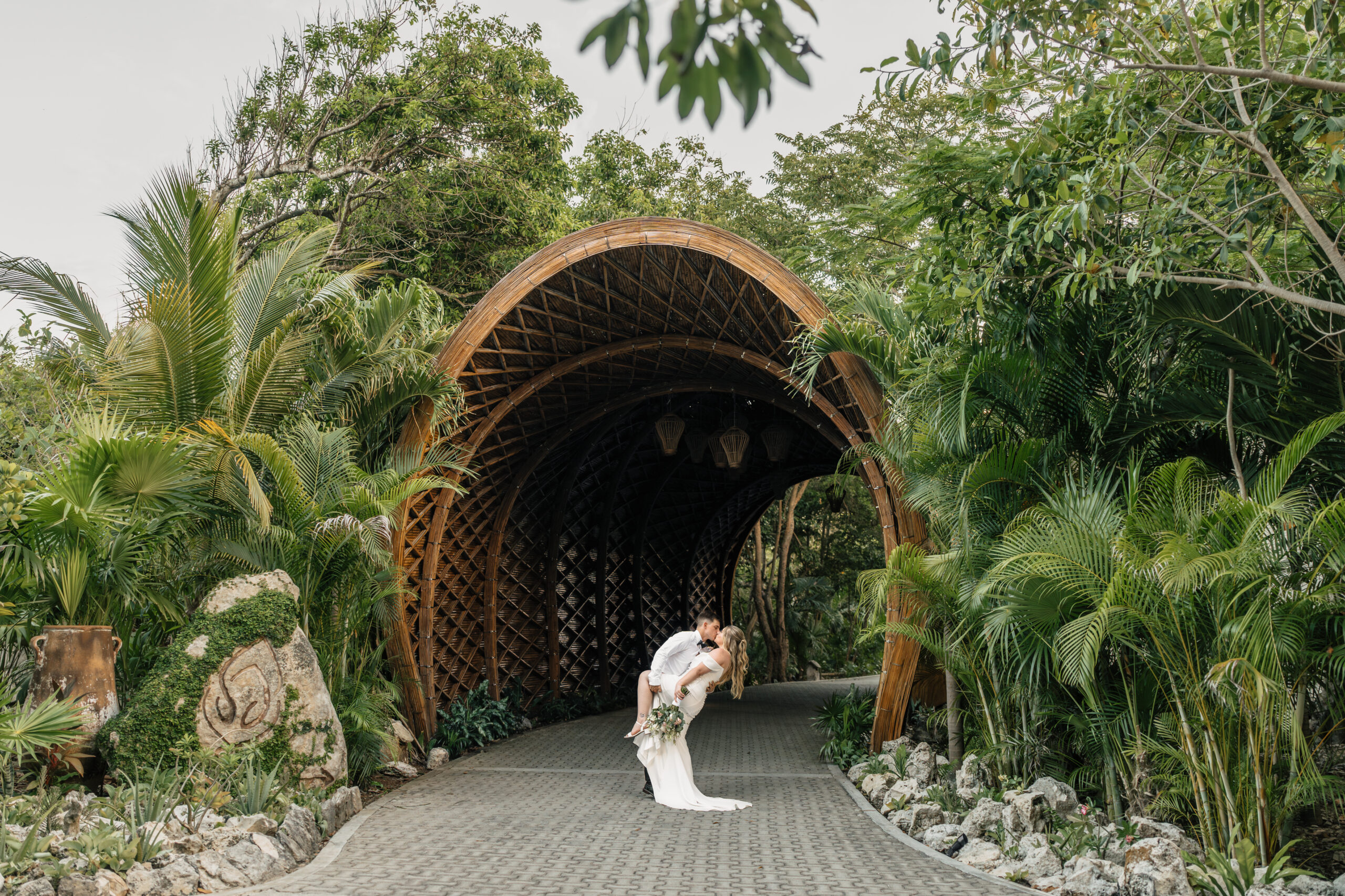 Bride and groom kissing under palm trees