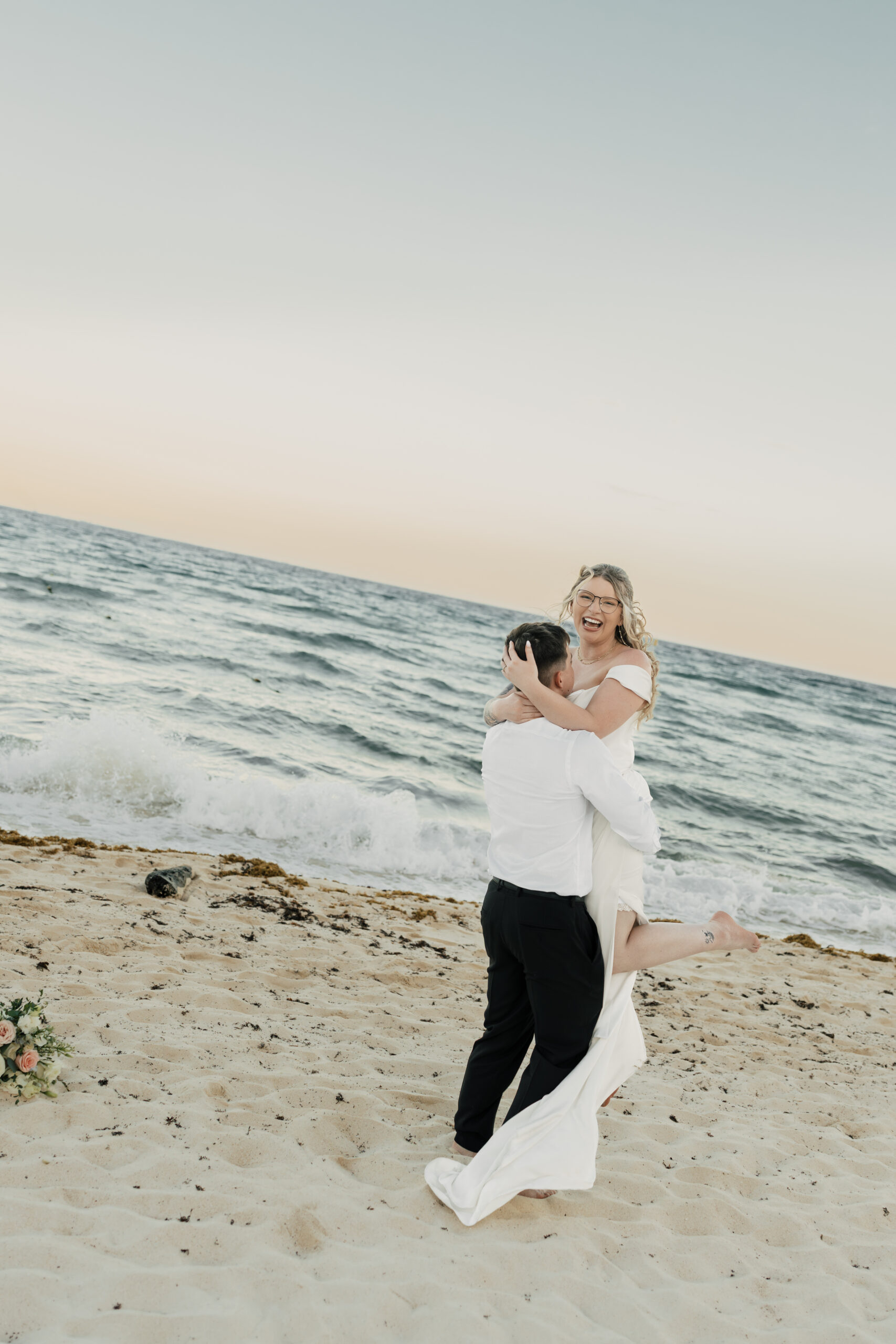 Playful post-ceremony portraits by turquoise water