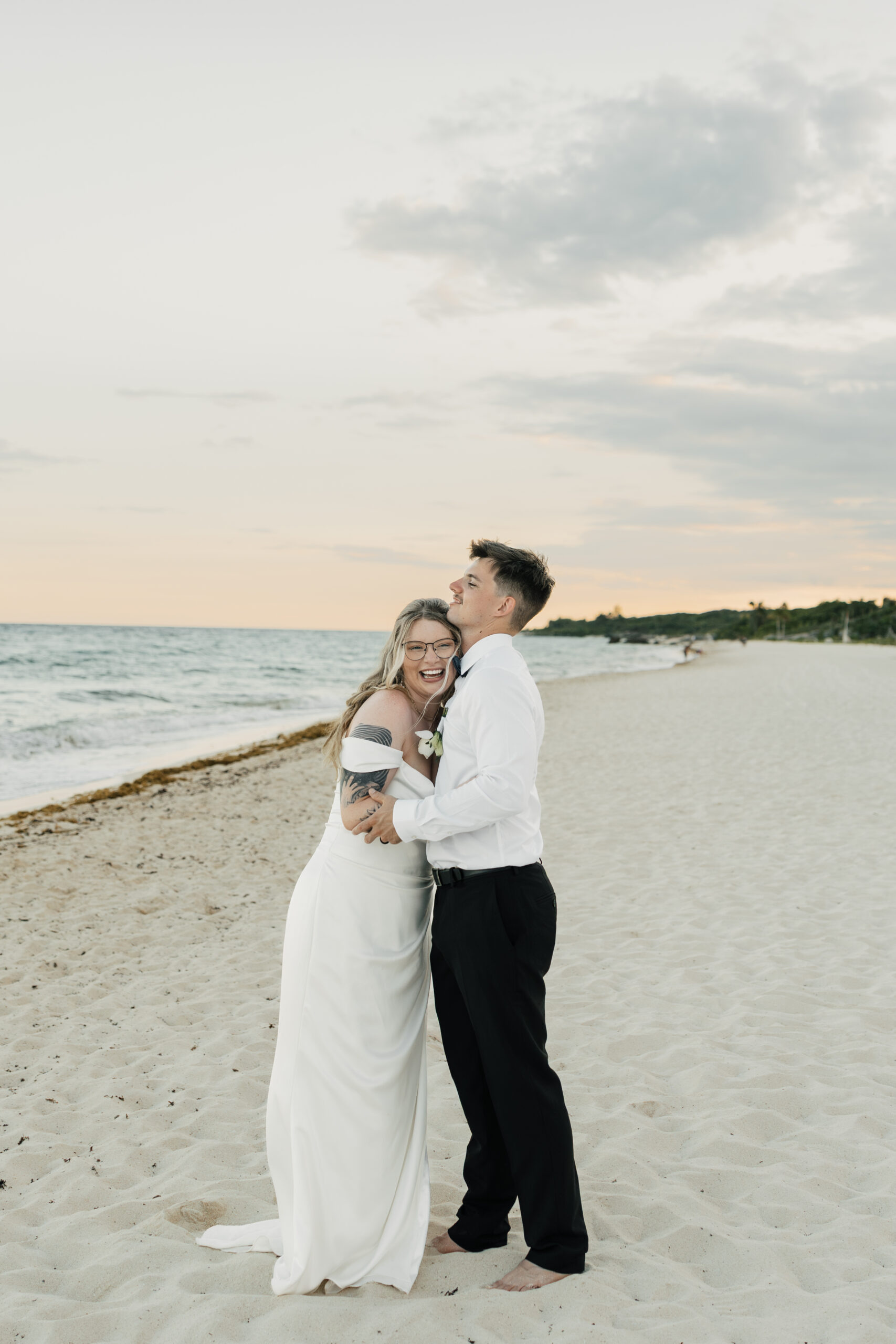 Newlyweds laughing during sunset beach photos