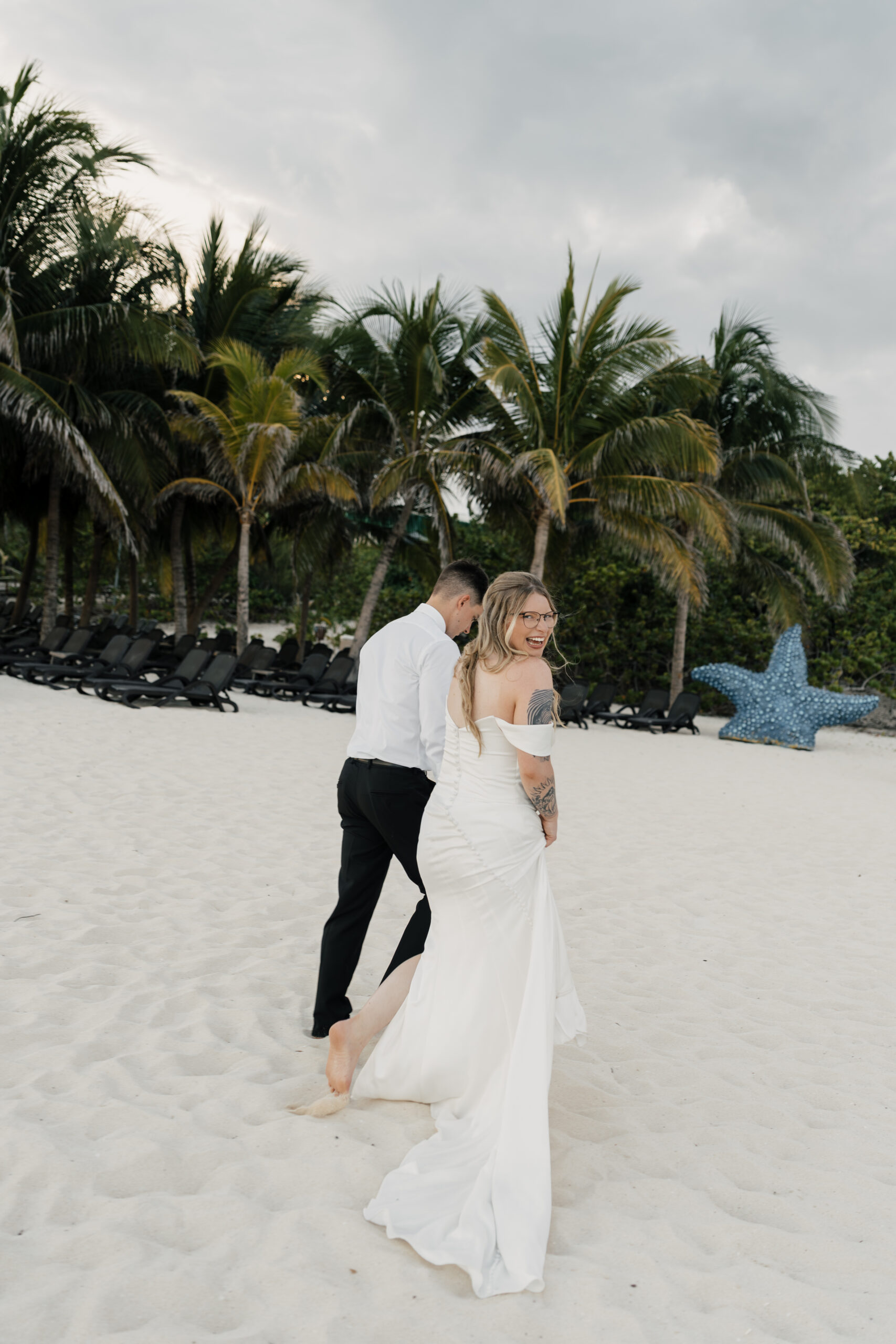 Couple holding hands along Sandos Playacar beach
