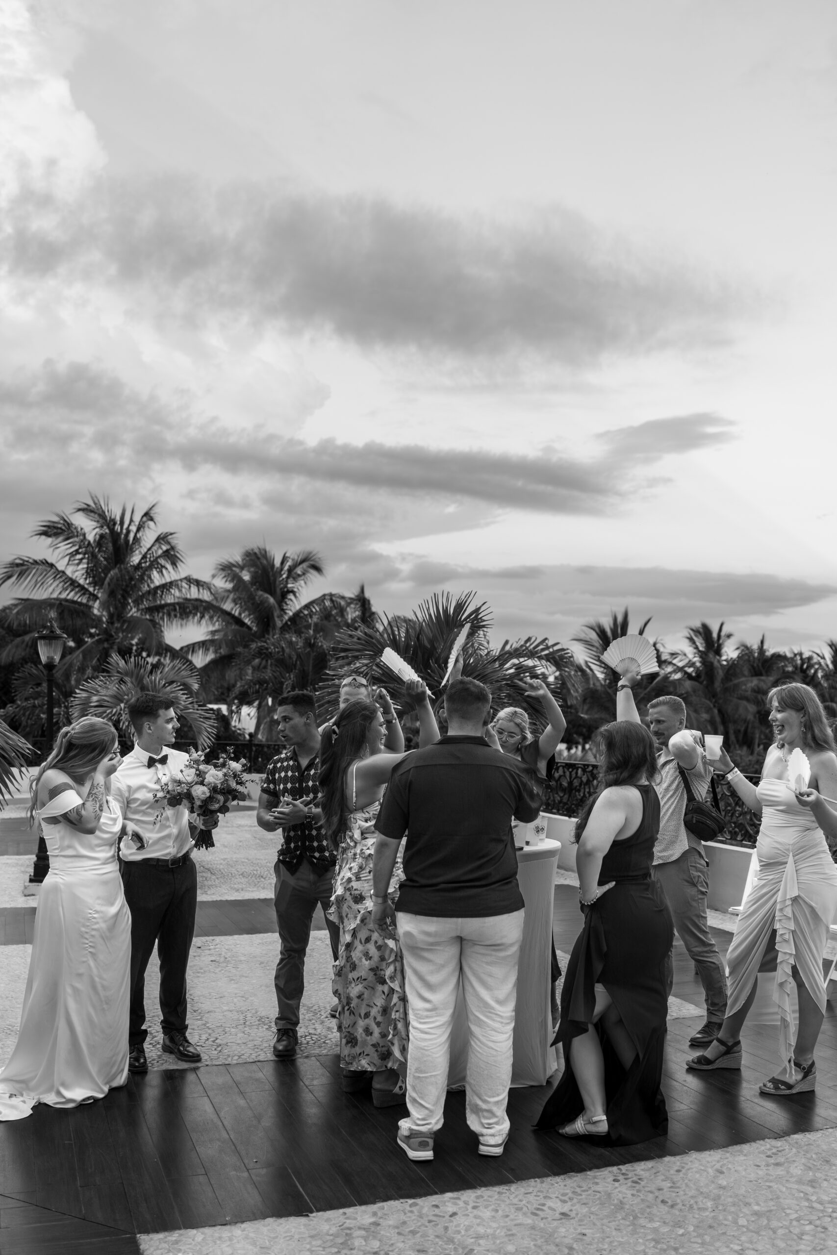 Guests laughing and chatting during cocktail hour by the beach