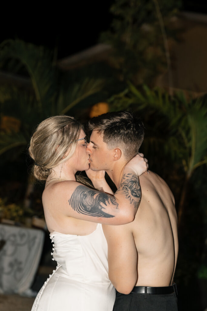 Final kiss during beach wedding night portraits