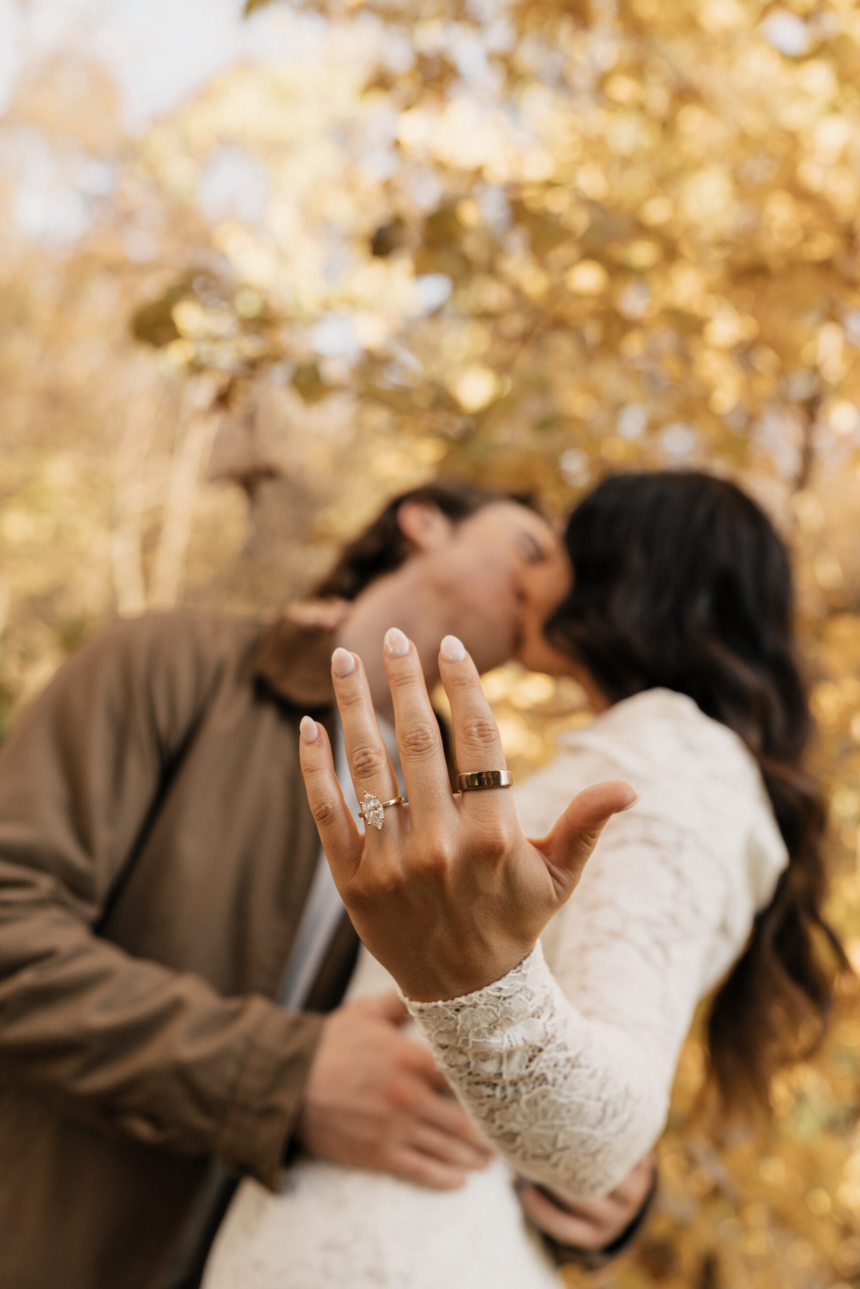 Creative overhead shot of couple lying in fall leaves, boots and hats visible