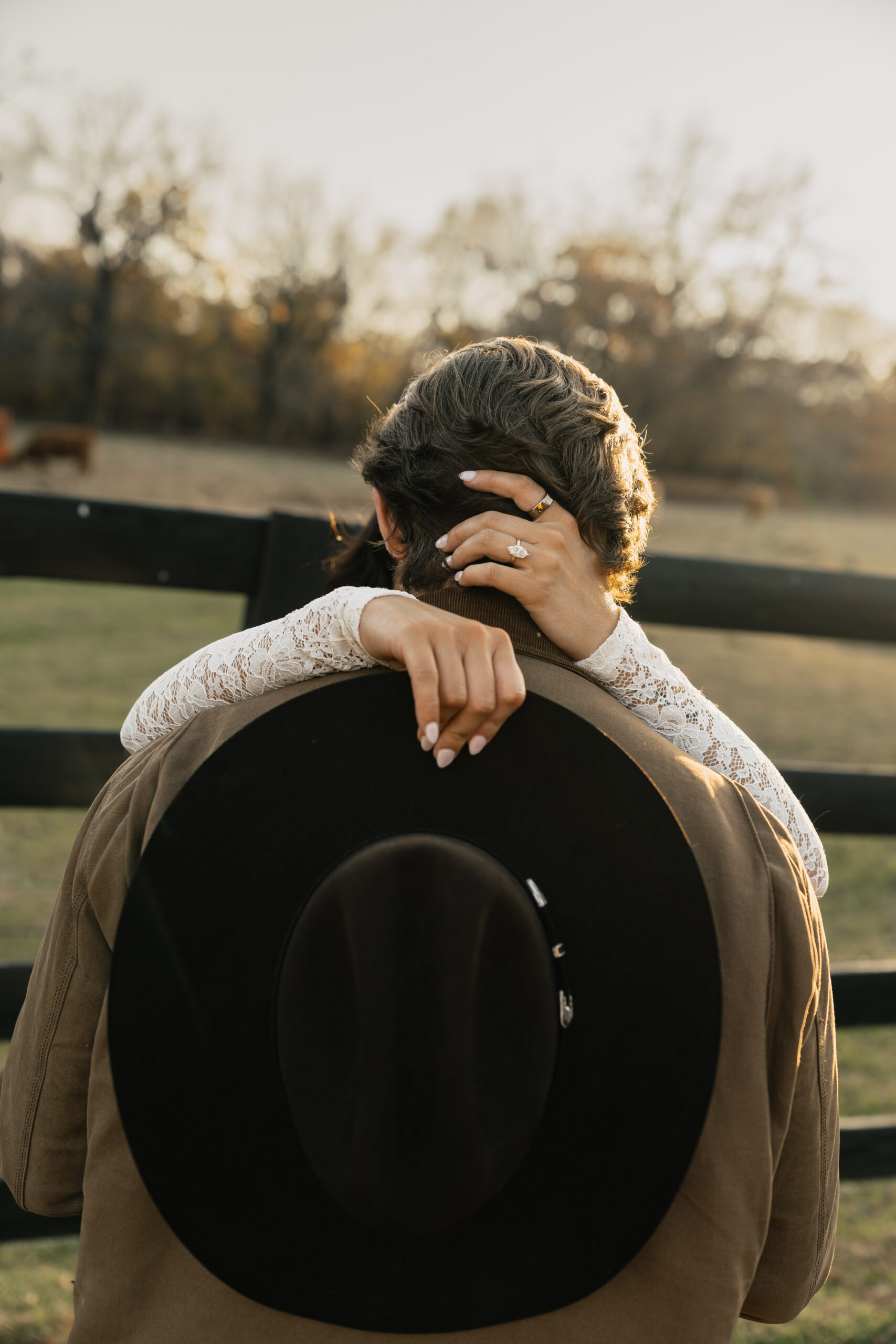 Engagement photo with fall leaves and tall grass, capturing playful interaction