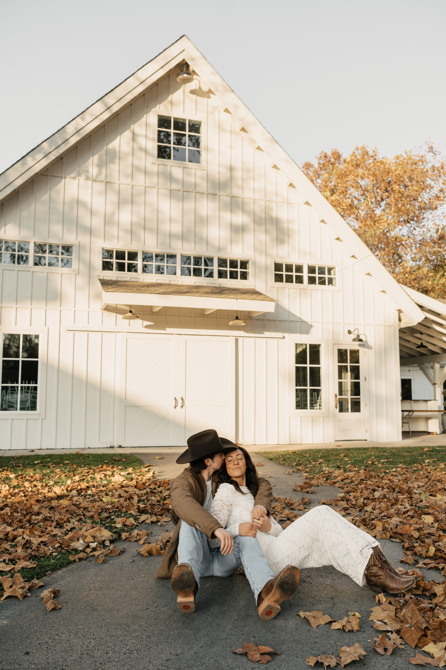 Golden hour engagement photo of couple walking through a rustic field at Spain Ranch