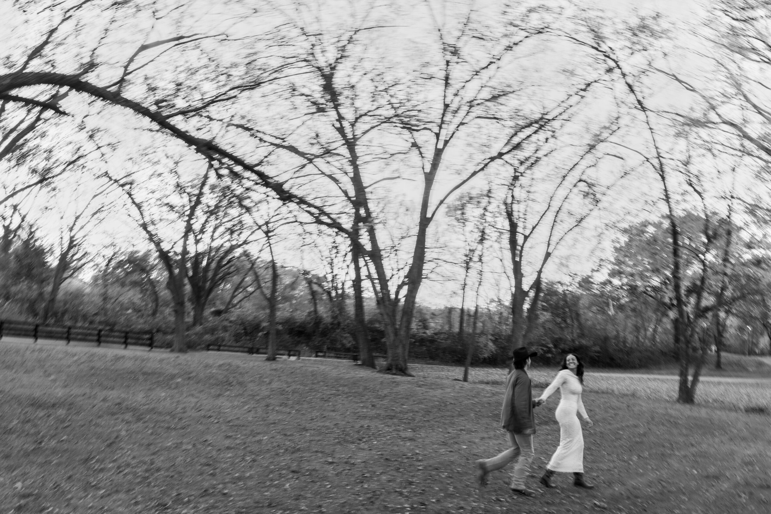 Couple holding hands in a golden fall field at Spain Ranch during their engagement session