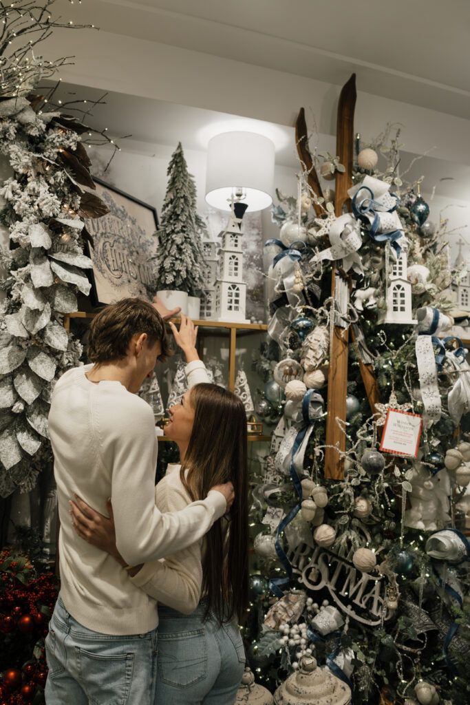 Couple posing with seasonal props in Tulsa Christmas photoshoot